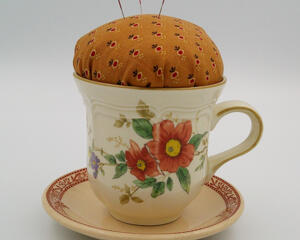 This is the front of the pincushion showing the flowers on the cup as well as the details on the trim of the saucer.